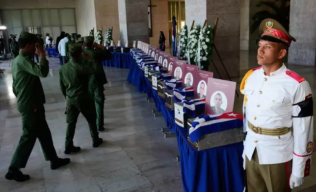 Military members pay their last respects to Cuban officers who were killed during the U.S. operation in Venezuela that captured Venezuelan President Nicolas Maduro, at the Ministry of the Revolutionary Armed Forces where the urns containing the remains are displayed during a ceremony in Havana, Cuba, Thursday, Jan. 15, 2026. (AP Photo/Ramon Espinosa)