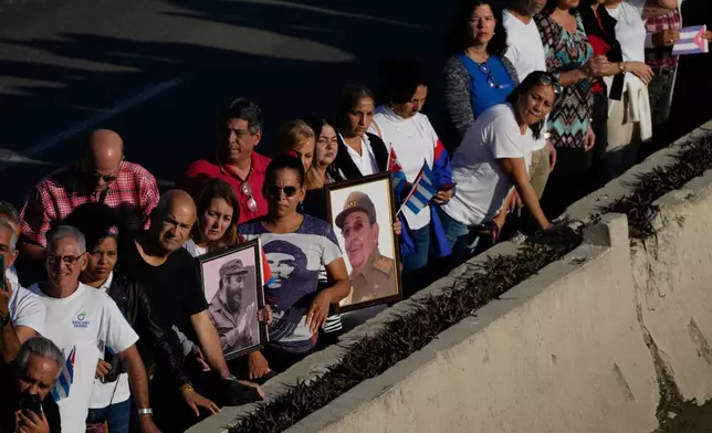 People line the streets of Havana, Cuba, Thursday, Jan. 15, 2026, to watch the motorcade carrying urns containing the remains of Cuban officers killed during the U.S. operation in Venezuela that captured Venezuelan President Nicolas Maduro. (AP Photo/Ramon Espinosa)
