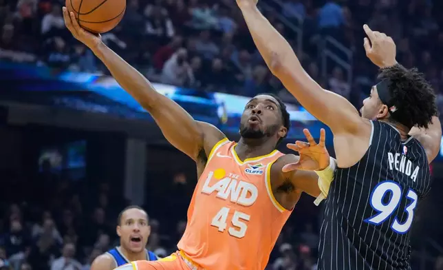 Cleveland Cavaliers guard Donovan Mitchell (45) goes to the basket past Orlando Magic forward Noah Penda (93) in the first half of an NBA basketball game in Cleveland, Monday, Jan. 26, 2026. (AP Photo/Sue Ogrocki)
