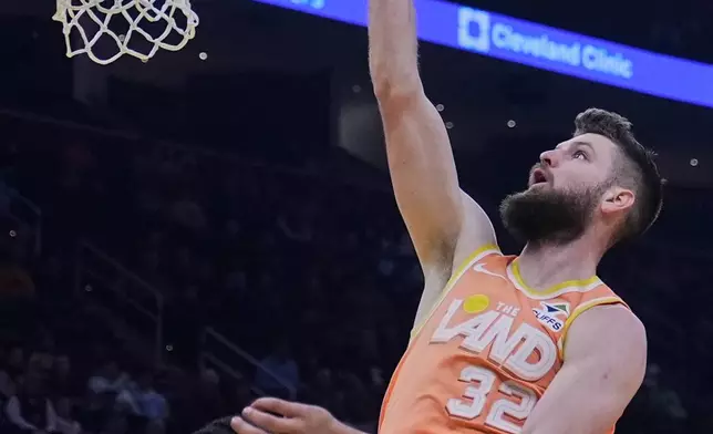 Cleveland Cavaliers forward Dean Wade (32) shoots over Orlando Magic guard Anthony Black, left, in the first half of an NBA basketball game in Cleveland, Monday, Jan. 26, 2026. (AP Photo/Sue Ogrocki)