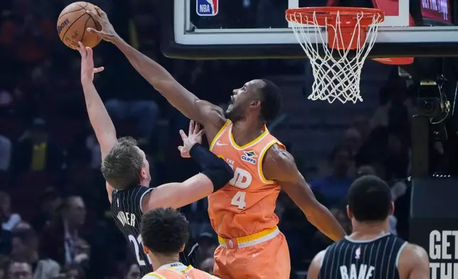 Cleveland Cavaliers center Evan Mobley (4) blocks a shot by Orlando Magic forward Moritz Wagner (21) in the first half of an NBA basketball game in Cleveland, Monday, Jan. 26, 2026. (AP Photo/Sue Ogrocki)