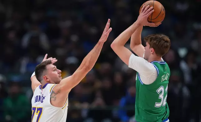 Dallas Mavericks forward Cooper Flagg (32) shoots against Los Angeles Lakers guard Luka Doncic (77) during the first half of an NBA basketball game Saturday, Jan. 24, 2026, in Dallas. (AP Photo/Julio Cortez)