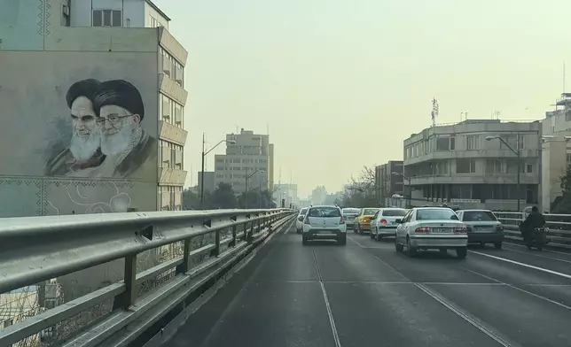 Vehicles drive past portrait of the late Iranian revolutionary founder Ayatollah Khomeini, left, and Supreme Leader Ayatollah Ali Khamenei, in downtown Tehran, Iran, Sunday, Jan. 25, 2026. (AP Photo/Vahid Salemi)