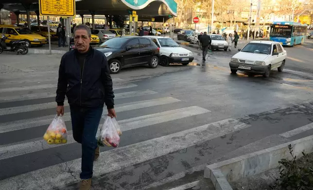 A man carries his shopping at Tajrish Sq. in northern Tehran, Iran, Tuesday, Jan. 27, 2026. (AP Photo/Vahid Salemi)