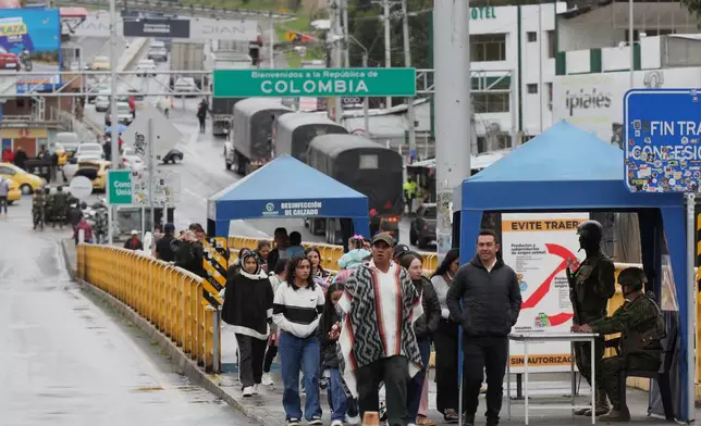 Pedestrians cross the Rumichaca international bridge from Colombia to Ecuador in Rumichaca, Colombia, Thursday, Jan. 22, 2026. (AP Photo/Leonardo Castro)