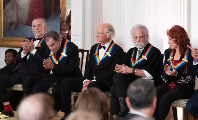 FILE - Kennedy Center Honors recipients from left; filmmaker Francis Ford Coppola, the legendary American rock band the Grateful Dead band members Mickey Hart, Bill Kreutzmann Bob Weir and blues rock singer-songwriter and guitarist Bonnie Raitt, applaud at at the 2024 Kennedy Center Honors reception in the East Room of the White House, Sunday, Dec. 8, 2024, in Washington. (AP Photo/Manuel Balce Ceneta,File)