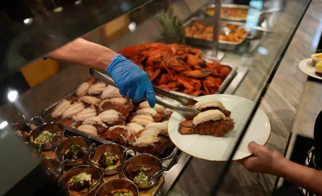 A person serves lobster tails at the A.Y.C.E Buffet in the Palms resort-casino Wednesday, Jan. 28, 2026, in Las Vegas. (AP Photo/John Locher)