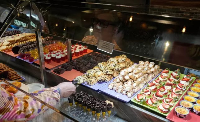 A person picks out dessert at the A.Y.C.E Buffet in the Palms resort-casino Wednesday, Jan. 28, 2026, in Las Vegas. (AP Photo/John Locher)