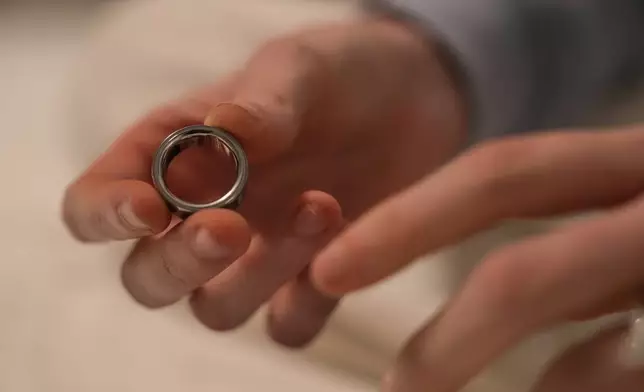Middle school teacher Kate Stoye puts on an Oura ring, a wearable sleep tracking device, Wednesday, Jan. 7, 2026, in Hiram, Ga. (AP Photo/Emilie Megnien)