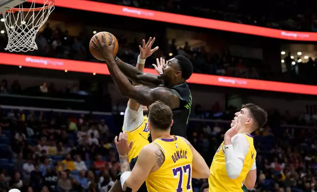 New Orleans Pelicans forward Zion Williamson shoots against center/Los Angeles Lakers forward Jaxson Hayes and forward/guard Luka Dončić (77) and forward Jake Laravia during the first half of an NBA basketball game in New Orleans, Tuesday, Jan. 6, 2026. (AP Photo/Matthew Hinton)