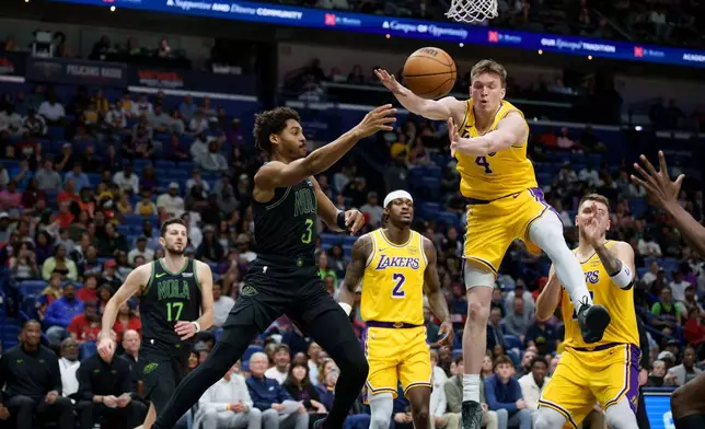New Orleans Pelicans guard Jordan Poole (3) passes around Los Angeles Lakers forward Dalton Knecht (4) during the first half of an NBA basketball game in New Orleans, Tuesday, Jan. 6, 2026. (AP Photo/Matthew Hinton)