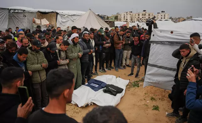 Mourners pray over the bodies of the Palestinian journalists Abd Shaat and Anas Ghoneim who were killed in an Israeli strike on an Egyptian committee's vehicle, during their funeral in Khan Younis, southern Gaza Strip, Thursday, Jan. 22, 2026. (AP Photo/Abdel Kareem Hana)