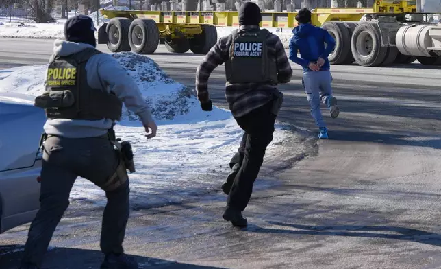 A man in handcuffs runs to avoid being detailed by federal immigration agents on Tuesday, Jan. 27, 2026, in Minneapolis. (AP Photo/Adam Gray)