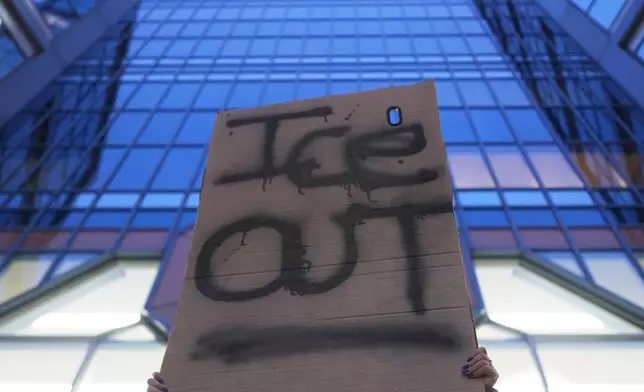 A demonstrator holds a sign reading "ICE OUT" during a protest outside the office of Sen. Amy Klobuchar, D-Minn., on Monday, Jan. 26, 2026, in Minneapolis. (AP Photo/Adam Gray)