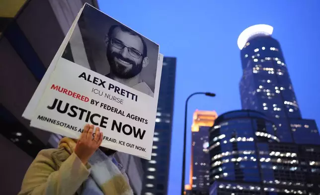 A person holds a sign of Alex Pretti during a protest outside the office of Sen. Amy Klobuchar, D-Minn., on Monday, Jan. 26, 2026, in Minneapolis. (AP Photo/Adam Gray)