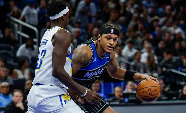 Orlando Magic forward Paolo Banchero, right, drives around Indiana Pacers forward Pascal Siakam during the first half of an NBA basketball game, Sunday, Jan. 4, 2026, in Orlando, Fla. (AP Photo/Kevin Kolczynski)