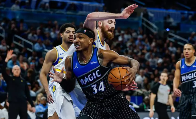 Orlando Magic center Wendell Carter Jr. (34) drives to the basket against Indiana Pacers center Jay Huff, left, during the first half of an NBA basketball game, Sunday, Jan. 4, 2026, in Orlando, Fla. (AP Photo/Kevin Kolczynski)