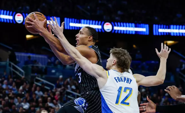 Orlando Magic guard Desmond Bane (3) goes to the basket defended by Indiana Pacers guard Johnny Furphy (12) during the first half of an NBA basketball game, Sunday, Jan. 4, 2026, in Orlando, Fla. (AP Photo/Kevin Kolczynski)