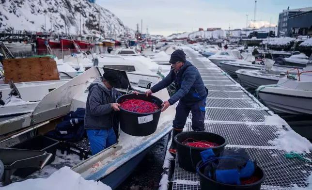 Fishermen load fishing lines into a boat in the harbor of Nuuk, Greenland, Wednesday, Jan. 14, 2026. (AP Photo/Evgeniy Maloletka)