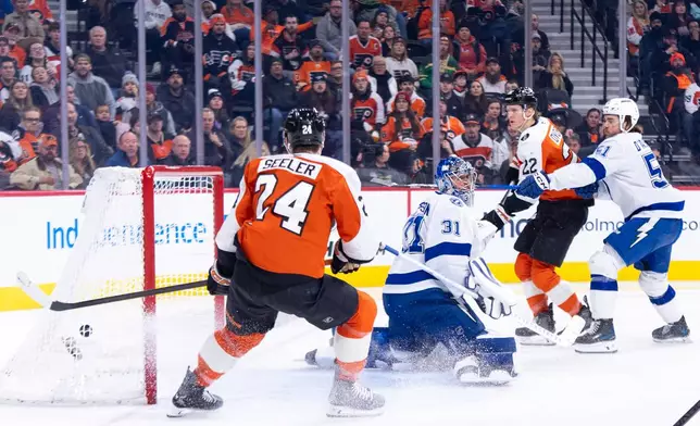 Philadelphia Flyers' Christian Dvorak, center right, shot gets past Tampa Bay Lightning's Jonas Johansson, center left, for a goal during the second period of an NHL hockey game, Monday, Jan. 12, 2026, in Philadelphia. (AP Photo/Chris Szagola)