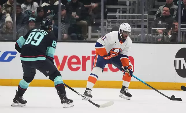 New York Islanders left wing Anthony Duclair (11) moves the puck against Seattle Kraken center Frederick Gaudreau (89) during the first period of an NHL hockey game Wednesday, Jan. 21, 2026, in Seattle. (AP Photo/Lindsey Wasson)