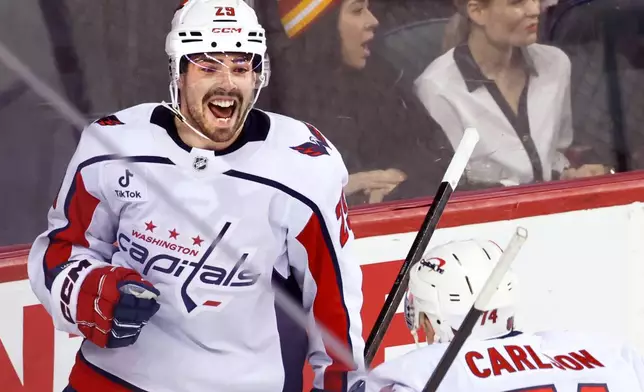 Washington Capitals' Hendrix Lapierre, left, celebrates after his goal against the Calgary Flames with John Carlson, right, during second-period NHL hockey game action in Calgary, Alberta, Friday, Jan. 23, 2026. (Larry MacDougal/The Canadian Press via AP)