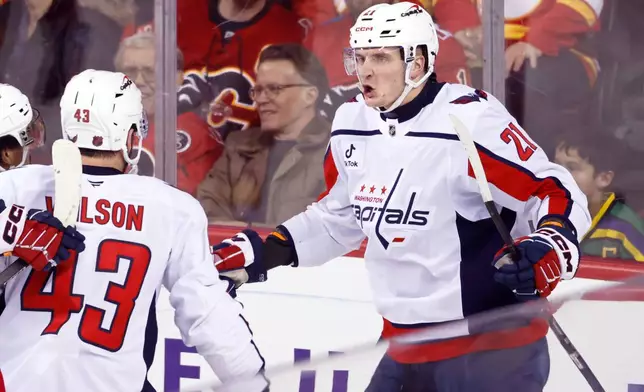 Washington Capitals' Aliaksei Protas, right, celebrates his goal against the Calgary Flames with teammates during the third period of an NHL hockey game in Calgary, Alberta, Friday, Jan. 23, 2026. (Larry MacDougal/The Canadian Press via AP)