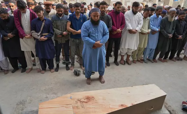 People offer funeral prayers of Shahroz Iqbal, who was killed in the shopping mall fire incident, in Karachi, Pakistan, Wednesday, Jan. 21, 2026. (AP Photo/Mohammad Farooq)