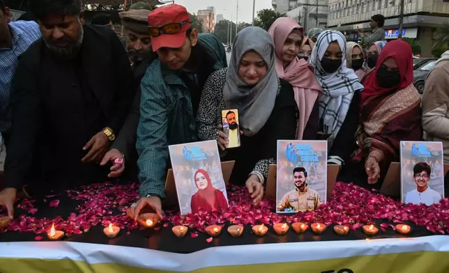 People take part in a candle light vigil for the victims of shopping mall fire incident, in Karachi, Pakistan, Wednesday, Jan. 21, 2026. (AP Photo/Ali Raza)