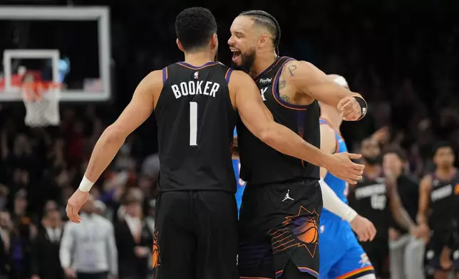 Phoenix Suns guard Devin Booker, left, celebrates with forward Dillon Brooks after hitting the winning shot against the Oklahoma City Thunder during the second half of an NBA basketball game, Sunday, Jan. 4, 2026, in Phoenix. (AP Photo/Rick Scuteri)