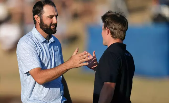 Scottie Scheffler, left, smiles as he shakes hands with Blades Brown after winning the American Express golf event on the Pete Dye Stadium Course at PGA West Sunday, Jan. 25, 2026, in La Quinta, Calif. (AP Photo/Ross D. Franklin)