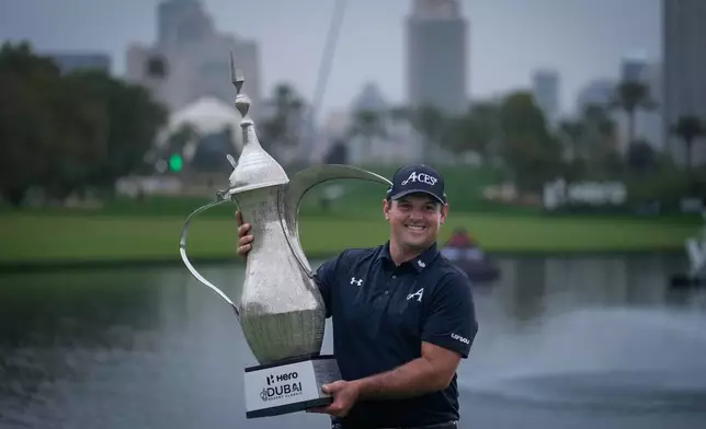 Patrick Reed of the United States poses with the Dubai Desert Classic trophy after winning it in Dubai, United Arab Emirates, Sunday, Jan. 25, 2026. (AP Photo/Altaf Qadri)