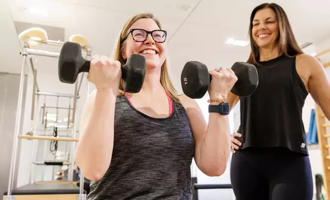 Sarah Baldassaro, left, demonstrates a strength-training regimen with her trainer, Hilary Granat, at the Center for Orthopedic Rehab and Exercise on Thursday, Jan. 8, 2026, in Washington. (AP Photo/Moriah Ratner)
