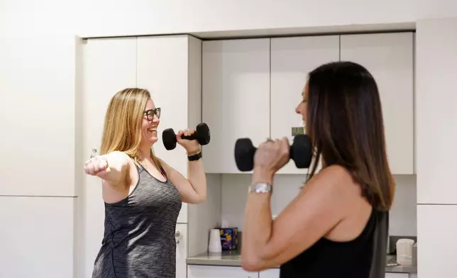 Sarah Baldassaro, left, demonstrates a strength-training regimen with her trainer, Hilary Granat, at the Center for Orthopedic Rehab and Exercise on Thursday, Jan. 8, 2026, in Washington. (AP Photo/Moriah Ratner)