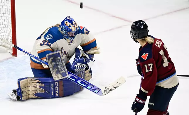 Vancouver Goldeneyes goalie Emerance Maschmeyer, left, juggles the puck as Montreal Victoire's Dara Greig, right, skates by during first-period PWHL hockey game action in Quebec City, Sunday, Jan. 11, 2026. (Jacques Boissinot/The Canadian Press via AP)