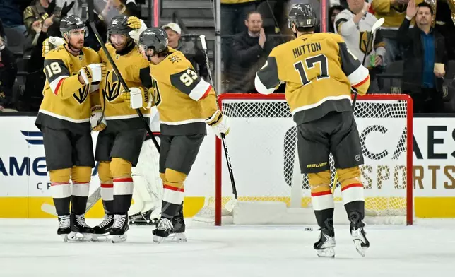 Vegas Golden Knights players celebrate after a goal against the Columbus Blue Jackets during the first period of an NHL hockey game Thursday, Jan. 8, 2026, in Las Vegas. (AP Photo/David Becker)
