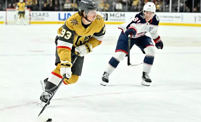 Vegas Golden Knights right wing Mitch Marner (93) handles the puck against Columbus Blue Jackets center Kent Johnson (91) during the second period of an NHL hockey game Thursday, Jan. 8, 2026, in Las Vegas. (AP Photo/David Becker)