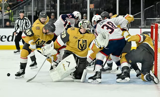 Vegas Golden Knights goaltender Carter Hart (79) defends the net against Columbus Blue Jackets players during the first period of an NHL hockey game Thursday, Jan. 8, 2026, in Las Vegas. (AP Photo/David Becker)