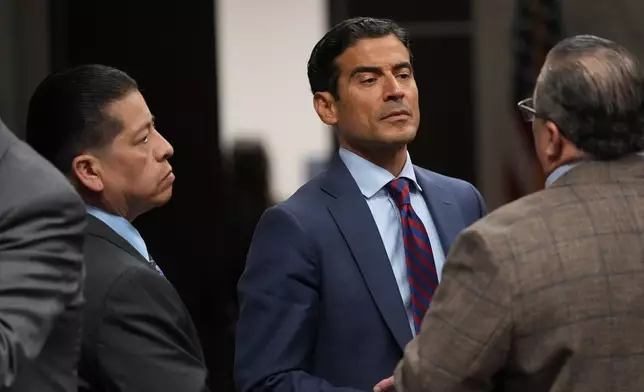 Former Uvalde school district police officer Adrian Gonzales, left, stands with his attorney Nico LaHood during a break in his trial at the Nueces County Courthouse in Corpus Christi, Texas, Tuesday, Jan. 6, 2026. (AP Photo/Eric Gay, Pool)