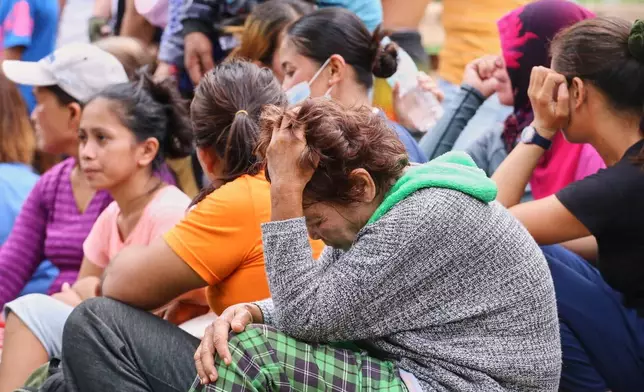 Relatives and others wait for updates after a huge mound of garbage collapsed at a waste segregation facility in Binaliw, Cebu city on Friday, Jan. 9, 2026. (AP Photo/Jacqueline Hernandez)