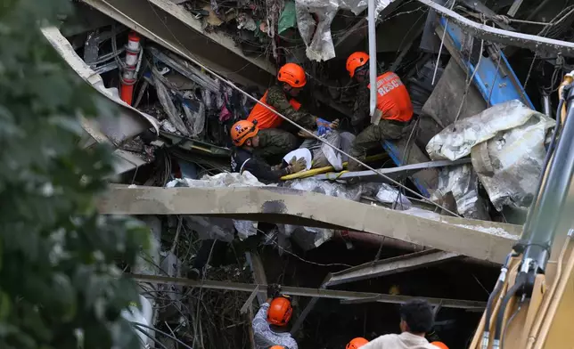 Rescuers retrieve a body inside a collapsed waste segregation facility in Binaliw, Cebu city, central Philippines on Friday, Jan. 9, 2026. (AP Photo/Jacqueline Hernandez)