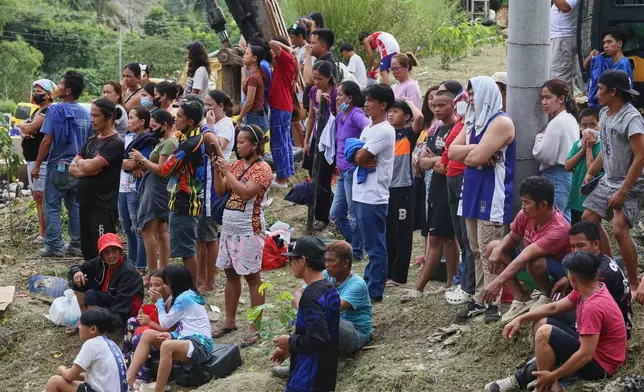 Relatives and others wait for updates after a huge mound of garbage collapsed at a waste segregation facility in Binaliw, Cebu city on Friday, Jan. 9, 2026. (AP Photo/Jacqueline Hernandez)