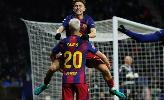 Barcelona's Dani Olmo (20) is congratulated by Fermin Lopez after scoring his side's opening goal during the Spanish La Liga soccer match between RCD Espanyol and Barcelona in Barcelona, Spain, Saturday, Jan. 3, 2026. (AP Photo/Joan Monfort)