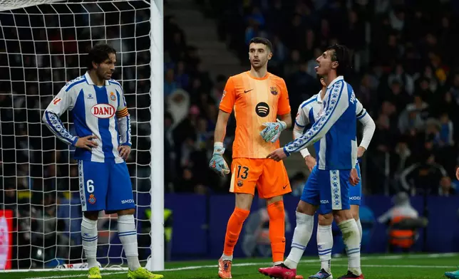 Espanyol's Pere Milla, right, reacts after missing a chance to score during the Spanish La Liga soccer match between RCD Espanyol and Barcelona in Barcelona, Spain, Saturday, Jan. 3, 2026. (AP Photo/Joan Monfort)