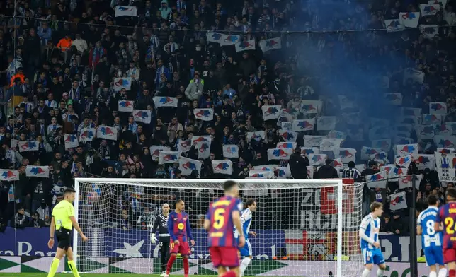 Espanyol fans hold up signs protesting Barcelona goalkeeper Joan Garcia during the Spanish La Liga soccer match between RCD Espanyol and Barcelona in Barcelona, Spain, Saturday, Jan. 3, 2026. (AP Photo/Joan Monfort)