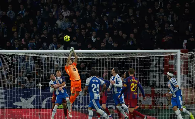 Barcelona's goalkeeper Joan Garcia, top, clears the ball during the Spanish La Liga soccer match between RCD Espanyol and Barcelona in Barcelona, Spain, Saturday, Jan. 3, 2026. (AP Photo/Joan Monfort)