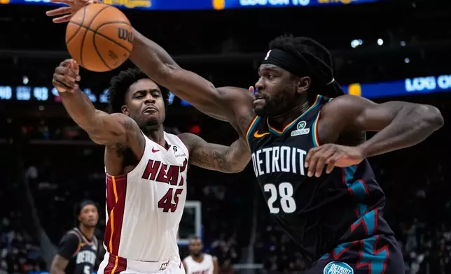 Miami Heat guard Davion Mitchell, left, and Detroit Pistons guard Cade Cunningham vie for the ball during the first half of an NBA basketball game, Thursday, Jan. 1, 2026, in Detroit. (AP Photo/Ryan Sun)