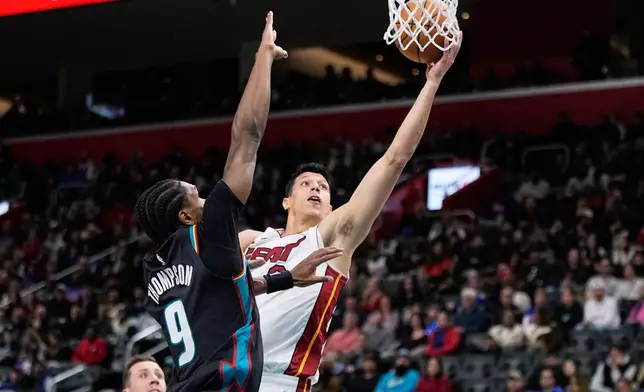Miami Heat forward Simone Fontecchio, right, shoots against Detroit Pistons guard Ausar Thompson during the first half of an NBA basketball game, Thursday, Jan. 1, 2026, in Detroit. (AP Photo/Ryan Sun)