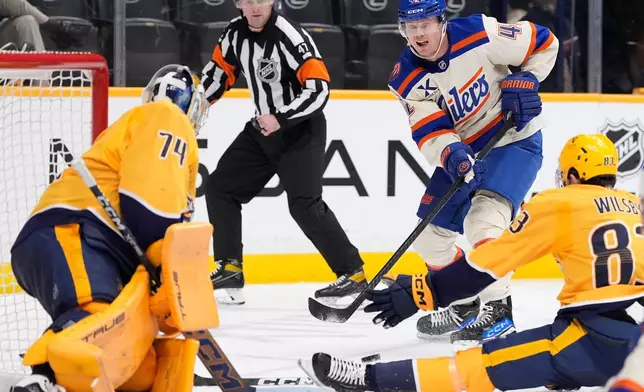 Edmonton Oilers right wing Kasperi Kapanen (42) has his shot on goal blocked by Nashville Predators defenseman Adam Wilsby (83) and goaltender Juuse Saros (74) during the third period of an NHL hockey game Tuesday, Jan. 13, 2026, in Nashville, Tenn. (AP Photo/George Walker IV)