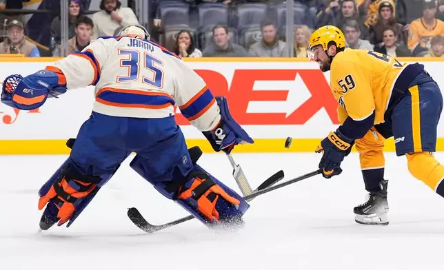 Nashville Predators defenseman Roman Josi (59) tries to get the puck past Edmonton Oilers goaltender Tristan Jarry (35) during overtime of an NHL hockey game Tuesday, Jan. 13, 2026, in Nashville, Tenn. (AP Photo/George Walker IV)
